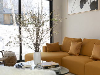 This stunning living room boasts a spacious sectional sofa in a rich mustard yellow, complemented by plush throw pillows.