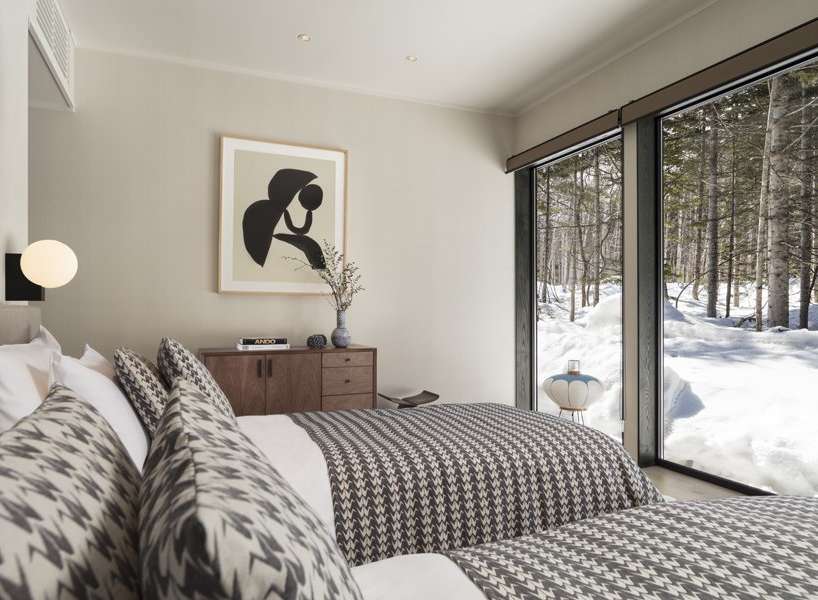 This stunning bedroom boasts a cozy and sophisticated atmosphere, featuring a chic monochrome color scheme and a comfortable bed with patterned bedding.