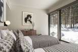 This stunning bedroom boasts a cozy and sophisticated atmosphere, featuring a chic monochrome color scheme and a comfortable bed with patterned bedding.
