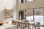 This stunning home boasts a spacious open-plan living area with floor-to-ceiling windows offering breathtaking views of a snowy landscape.