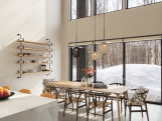 This stunning home boasts a spacious open-plan living area with floor-to-ceiling windows offering breathtaking views of a snowy landscape.