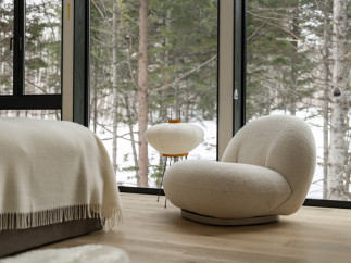 Cozy bedroom with floor-to-ceiling windows showcasing a snowy forest view.