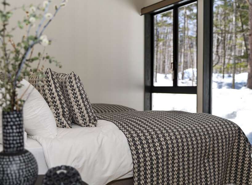 Wake up to stunning views of a snow-covered forest from this cozy bedroom.