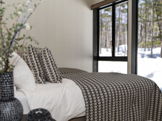 Wake up to stunning views of a snow-covered forest from this cozy bedroom.