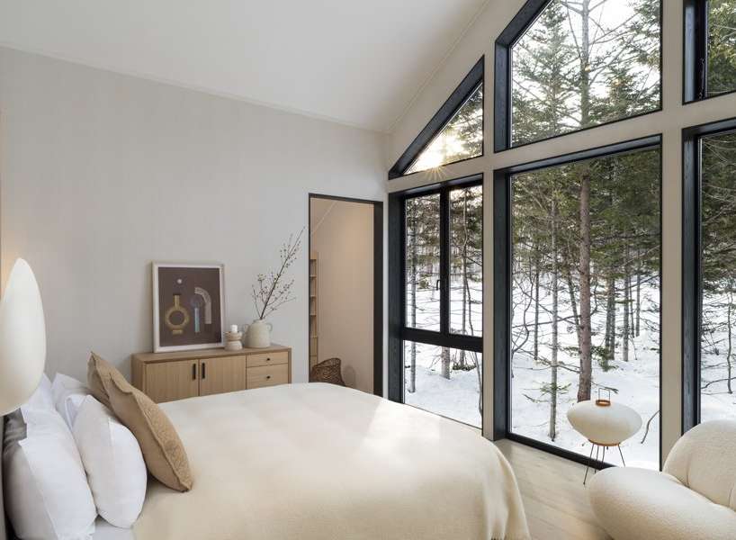 Wake up to breathtaking views of a snow-covered forest from this luxurious bedroom.