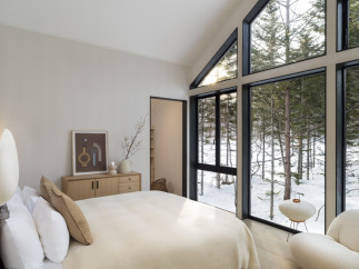 Wake up to breathtaking views of a snow-covered forest from this luxurious bedroom.