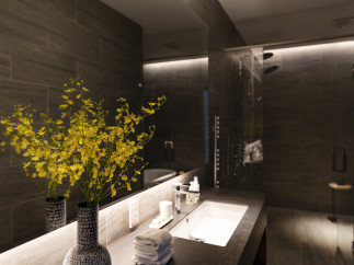 Luxurious bathroom with dark gray tile, modern sink and fixtures, and yellow orchids adding a touch of elegance.