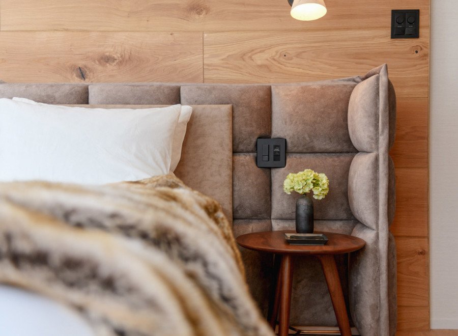 This luxurious bedroom boasts a plush upholstered headboard with built-in lighting and power outlets for ultimate convenience.