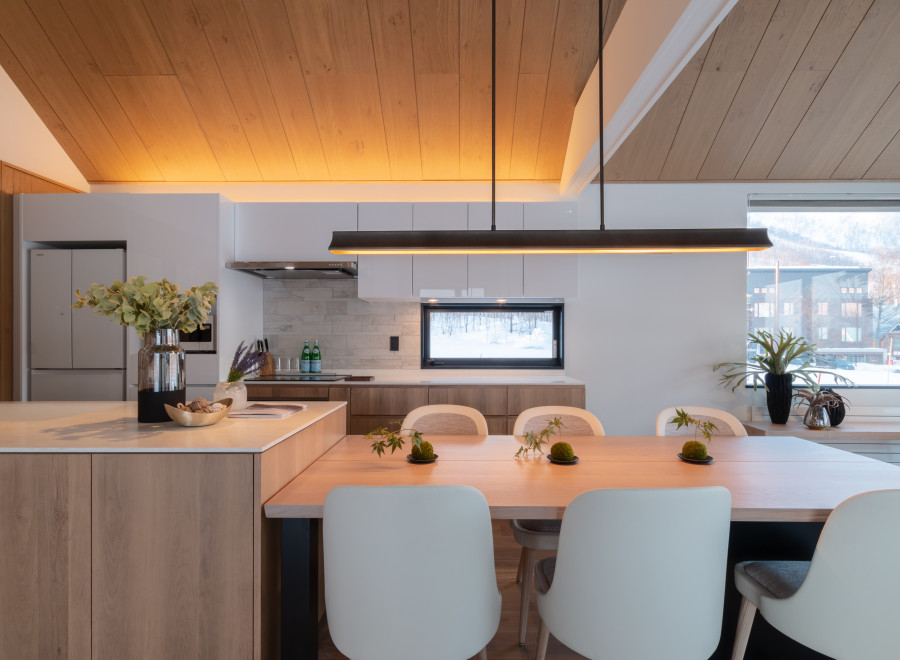 This stunning modern kitchen boasts a sleek design with light wood cabinets and a large island, perfect for entertaining.