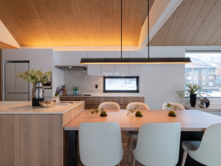 This stunning modern kitchen boasts a sleek design with light wood cabinets and a large island, perfect for entertaining.