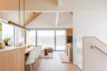 This stunning property boasts an open-concept living area with floor-to-ceiling windows offering breathtaking views of a snow-covered landscape.