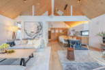 This stunning property boasts an open-concept living area with vaulted ceilings and large windows, creating a bright and airy atmosphere.
