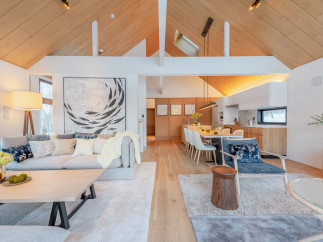 This stunning property boasts an open-concept living area with vaulted ceilings and large windows, creating a bright and airy atmosphere.