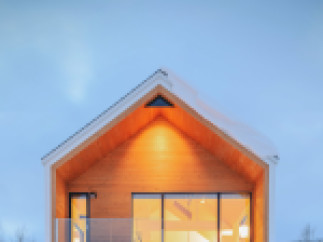 This stunning modern chalet boasts a sleek design with a wood exterior, large windows offering abundant natural light, and a spacious garage.
