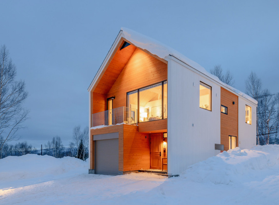 This stunning modern home boasts a unique design with a blend of white and wood siding, creating a cozy yet contemporary feel.
