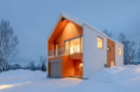 This stunning modern home boasts a unique design with a blend of white and wood siding, creating a cozy yet contemporary feel.