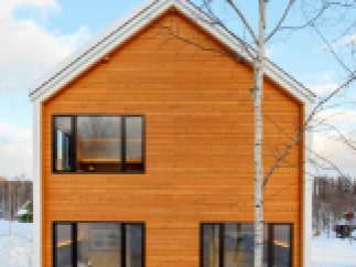 This stunning A-frame cabin boasts a modern design with expansive windows offering breathtaking views of the snowy landscape.