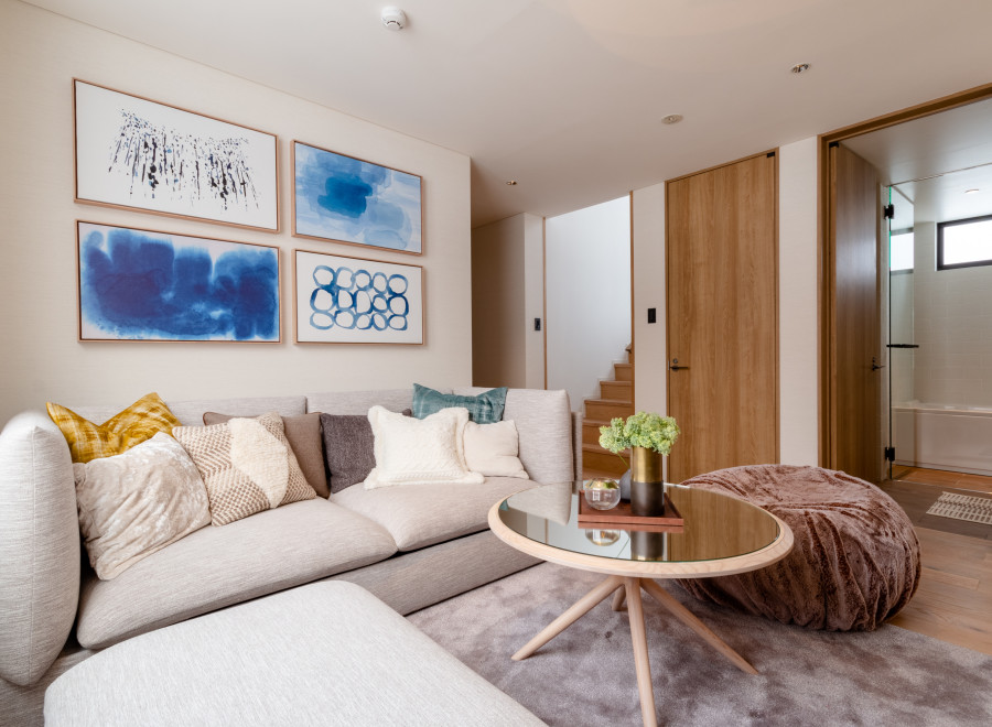 This stunning living room boasts a light and airy feel, complemented by a cozy sectional sofa and plush pouf.