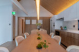 This stunning property boasts a spacious, light-filled dining area with a long wooden table perfect for gatherings.