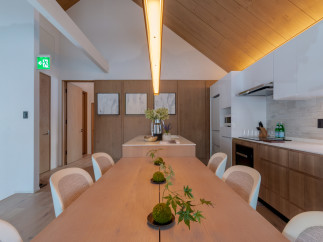 This stunning property boasts a spacious, light-filled dining area with a long wooden table perfect for gatherings.
