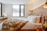 This luxurious bedroom boasts a king-size bed with plush bedding and a cozy faux fur throw, perfect for relaxing after a day on the slopes.
