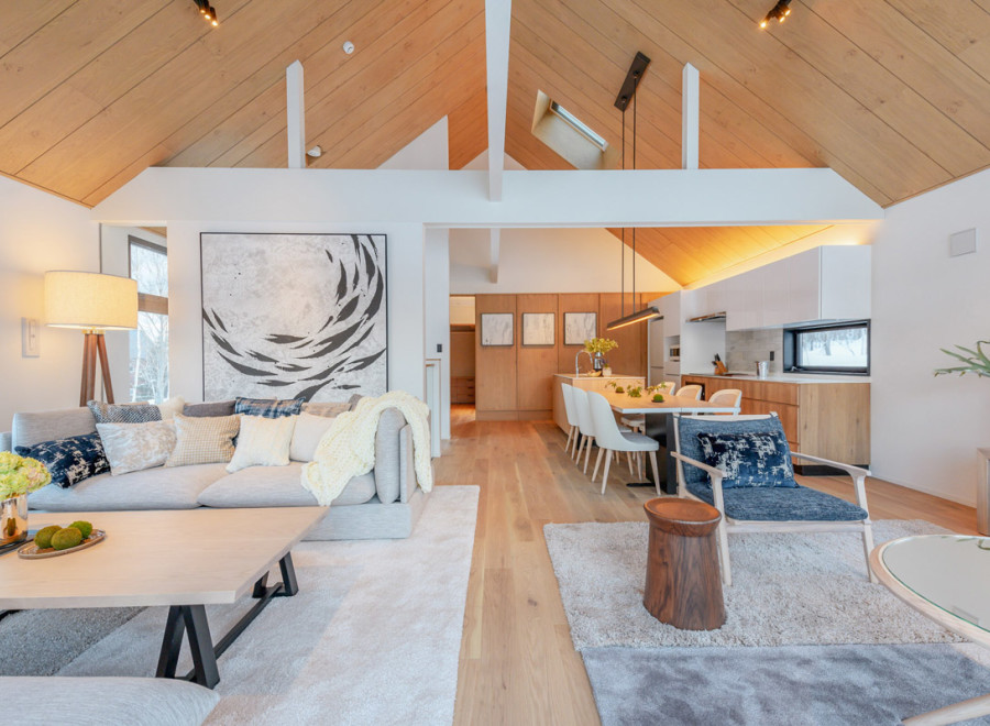 This stunning property boasts an open-concept living area with vaulted ceilings and large windows, creating a bright and airy atmosphere.