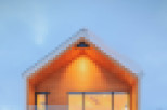 This stunning modern chalet boasts a sleek design with a wood exterior, large windows offering abundant natural light, and a spacious garage.