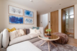 This stunning living room boasts a light and airy feel, complemented by a cozy sectional sofa and plush pouf.
