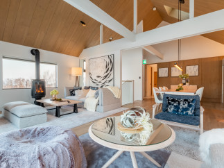 This stunning property boasts a spacious open-plan living area with vaulted ceilings and large windows offering breathtaking views.