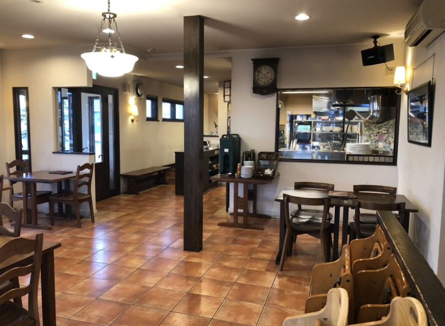 This cozy restaurant boasts a warm, inviting atmosphere with terracotta tile floors and dark wood furniture.