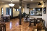 This cozy restaurant boasts a warm, inviting atmosphere with terracotta tile floors and dark wood furniture.