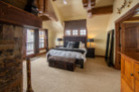 Luxurious mountaintop bedroom with stunning views, featuring a king-size bed, plush carpet, and a cozy fireplace.