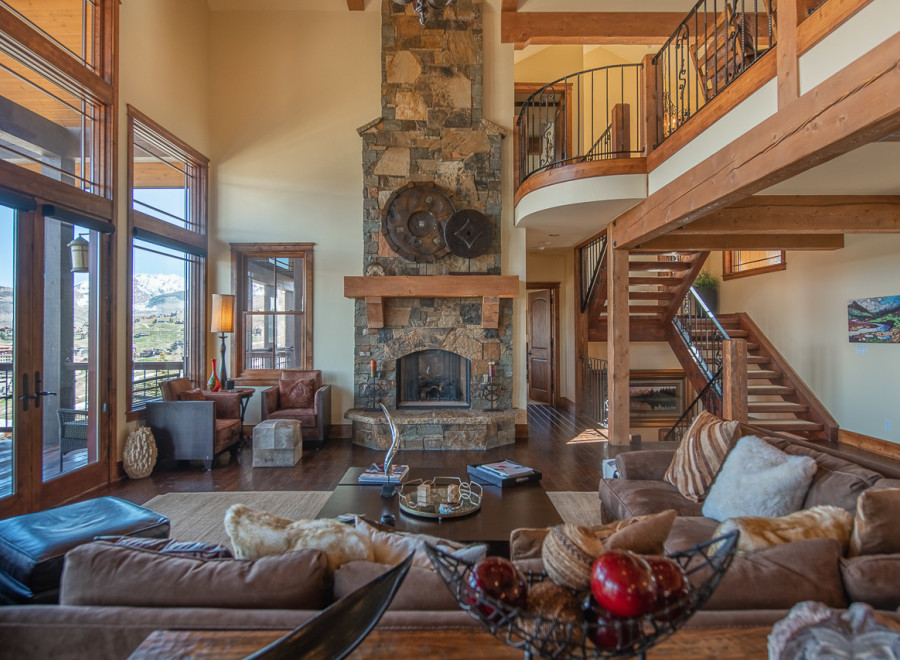 This stunning mountain home boasts a spacious open-plan living area with floor-to-ceiling windows offering breathtaking views.