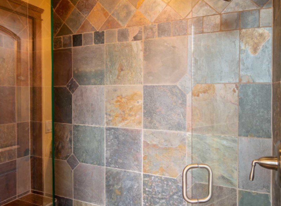 This luxurious bathroom boasts a spacious shower with stunning slate tile work, creating a spa-like atmosphere.