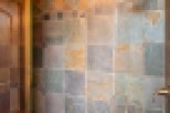 This luxurious bathroom boasts a spacious shower with stunning slate tile work, creating a spa-like atmosphere.
