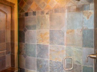 This luxurious bathroom boasts a spacious shower with stunning slate tile work, creating a spa-like atmosphere.