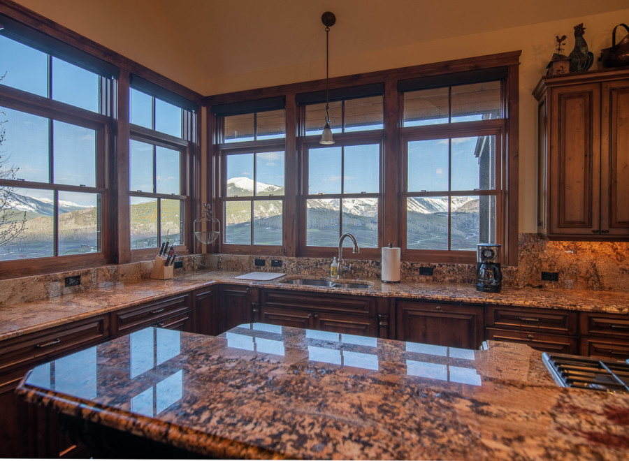 This stunning kitchen boasts breathtaking mountain views from its expansive windows, creating a bright and airy atmosphere.