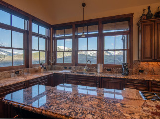 This stunning kitchen boasts breathtaking mountain views from its expansive windows, creating a bright and airy atmosphere.