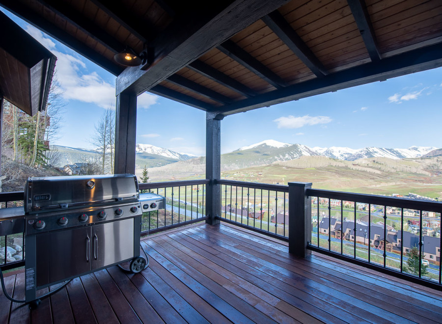 Luxury mountain retreat with expansive deck boasting breathtaking views.