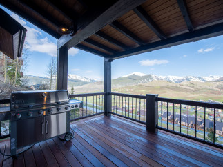 Luxury mountain retreat with expansive deck boasting breathtaking views.