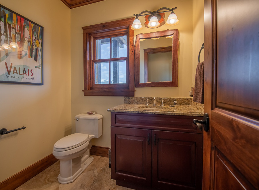 This stunning bathroom boasts a rustic-chic design with rich wood finishes and granite countertops.