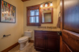 This stunning bathroom boasts a rustic-chic design with rich wood finishes and granite countertops.