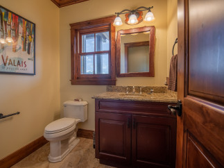 This stunning bathroom boasts a rustic-chic design with rich wood finishes and granite countertops.