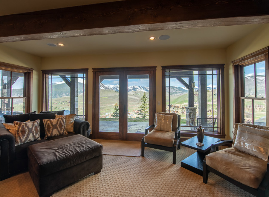 Mountain view living room with large windows and comfortable seating.