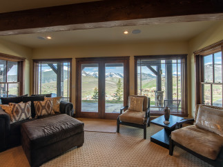 Mountain view living room with large windows and comfortable seating.