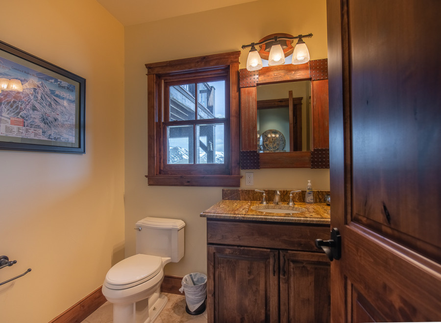 This luxurious bathroom boasts a stunning granite countertop, rich wood cabinetry, and a spacious layout.