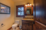 This luxurious bathroom boasts a stunning granite countertop, rich wood cabinetry, and a spacious layout.