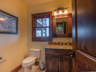 This luxurious bathroom boasts a stunning granite countertop, rich wood cabinetry, and a spacious layout.