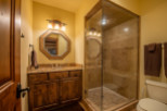This luxurious bathroom boasts a spacious walk-in shower with glass enclosure and elegant stone tile.