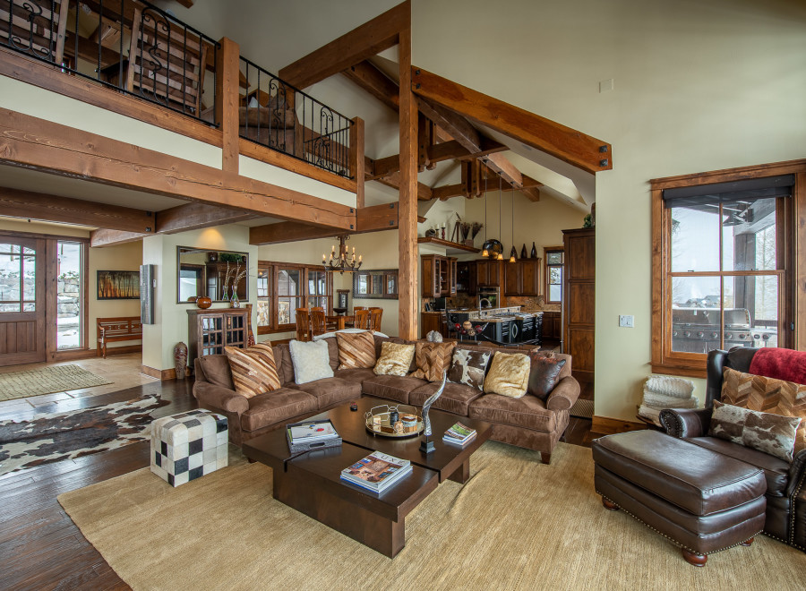 This stunning mountain home boasts a spacious open floor plan with soaring ceilings and exposed wooden beams.